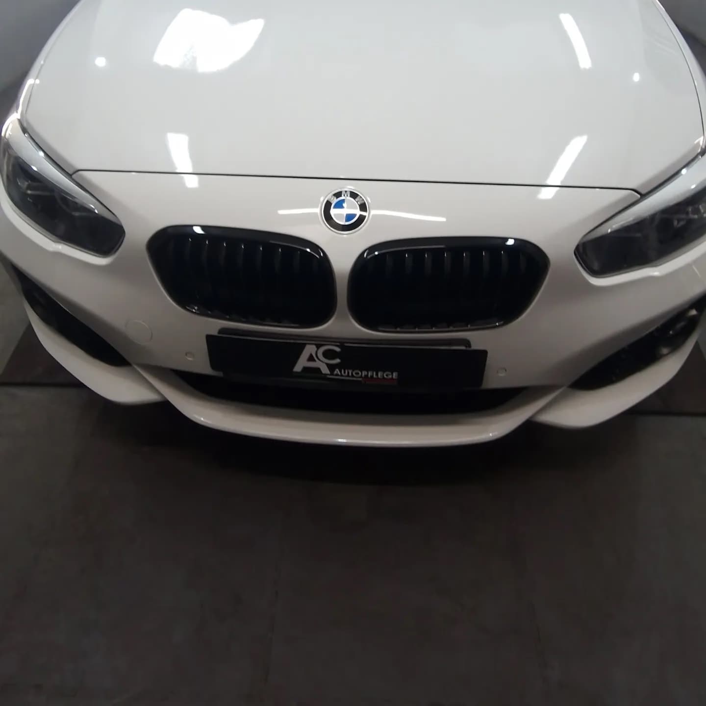 Frontpartie eines weißen BMW 1er nach der Keramikversiegelung mit Nanolex Cerabide.